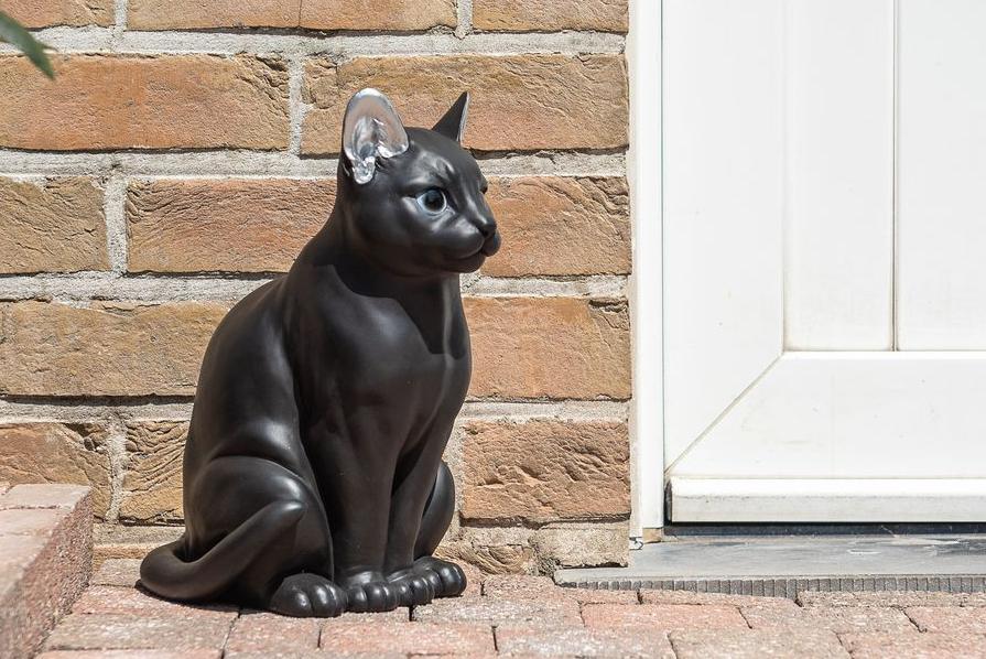 Statues of a modern black and silver cat standing next to a door Garden ID