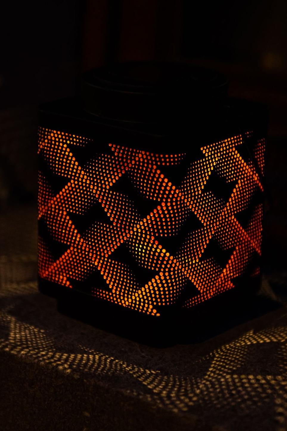 Cube-shaped solar-powered lantern with geometric shapes and orange light Garden ID