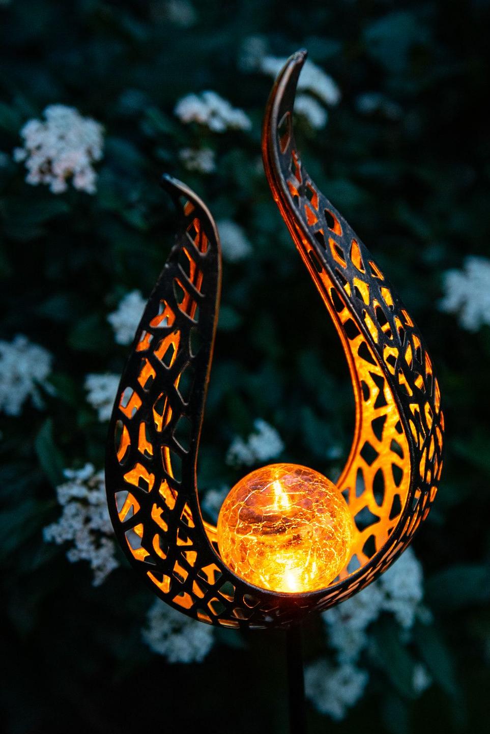 Decoratieve solarlamp op een paal in de vorm van een open vlam met een glazen bol die een oranje kleur met vurig effect uitstraalt Garden ID