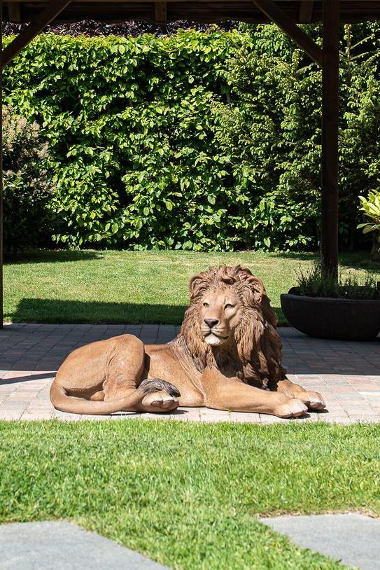 Garden ID-een standbeeld van een leeuw die zich koestert in de zon